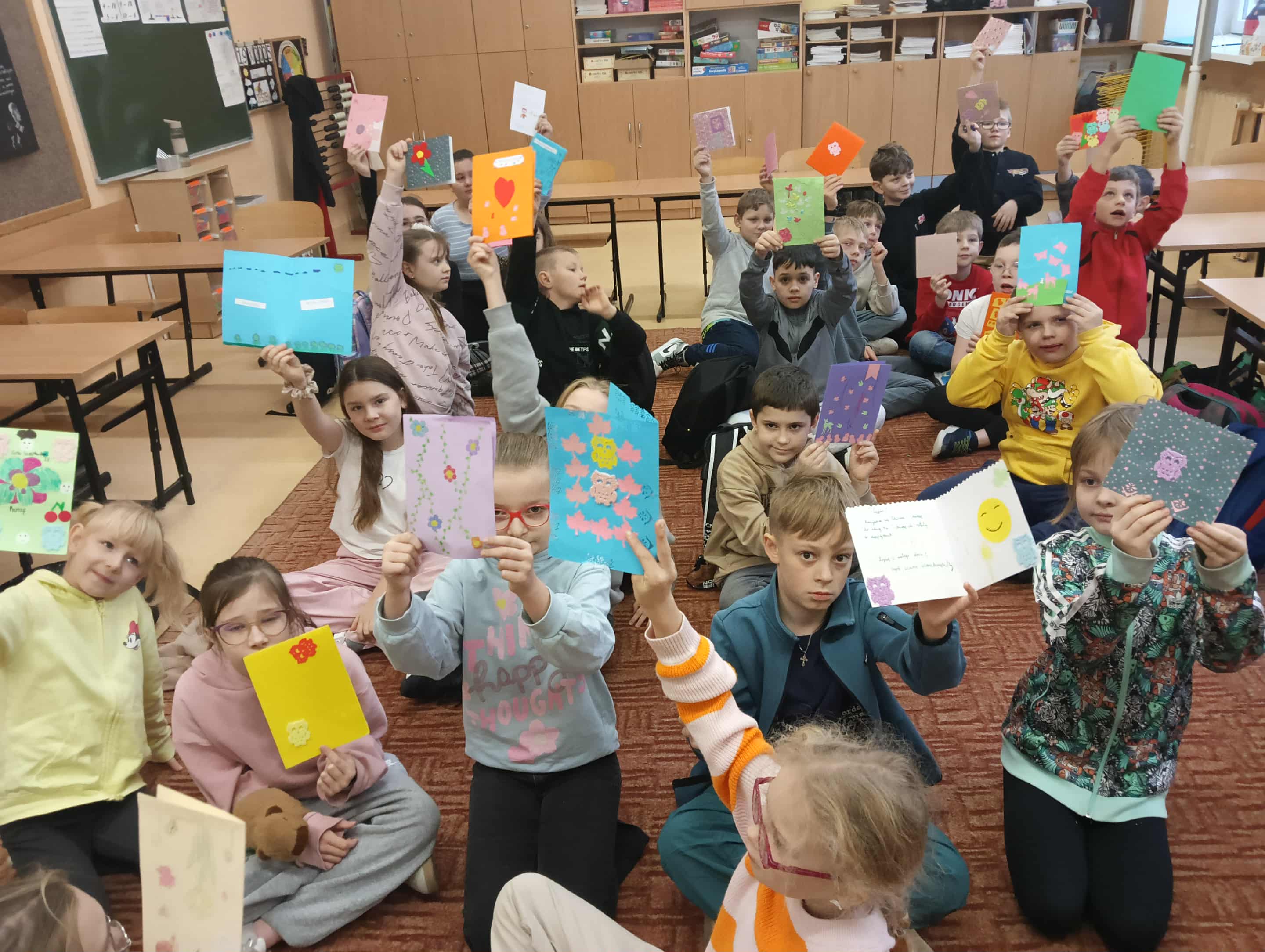 Uczniowie trzymają kartki otrzymane z okazji dnia życzliwości